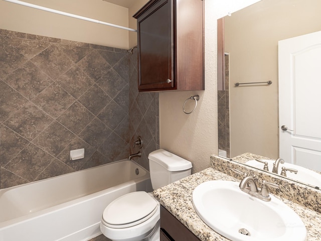 full bathroom featuring tiled shower / bath, vanity, and toilet