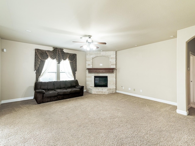 unfurnished living room with a fireplace, ceiling fan, and carpet flooring