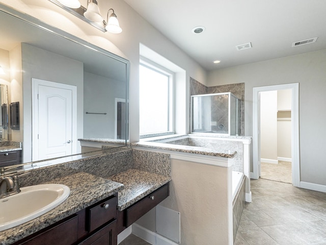 bathroom featuring tile patterned flooring, vanity, and plus walk in shower