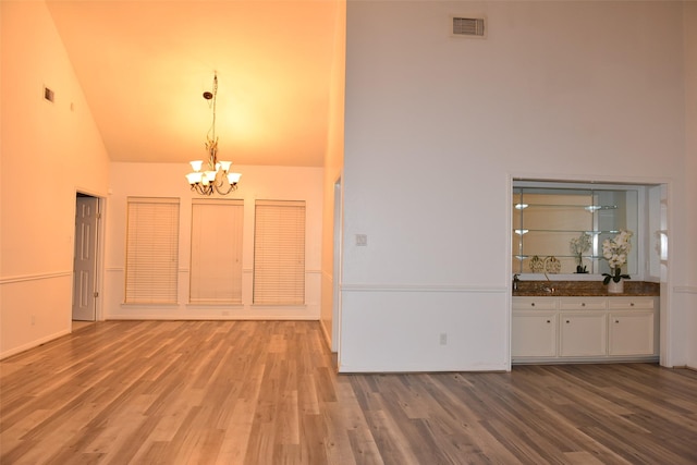 interior space featuring hardwood / wood-style flooring, high vaulted ceiling, and a chandelier