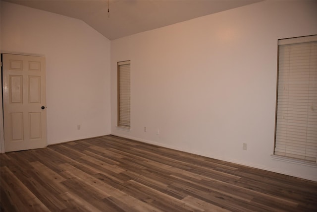 unfurnished room featuring lofted ceiling and dark hardwood / wood-style floors