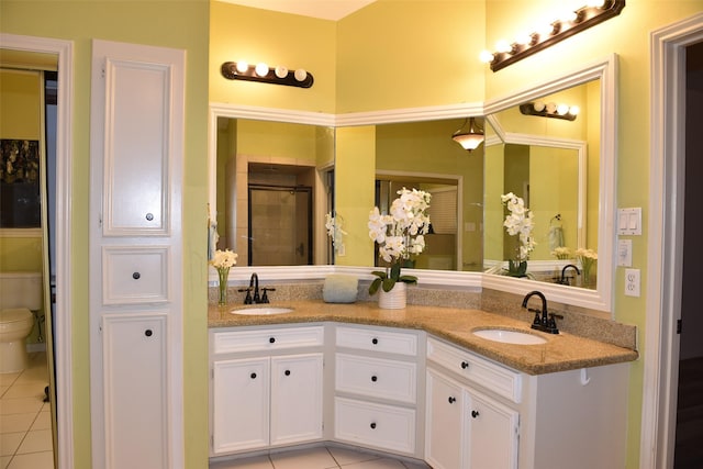 bathroom with vanity, toilet, a shower with door, and tile patterned flooring