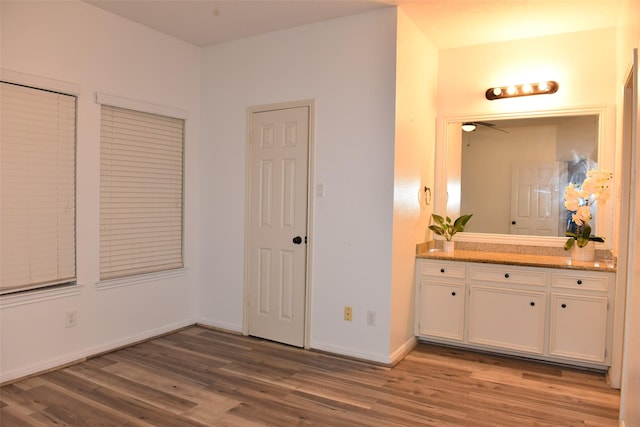 unfurnished bedroom featuring hardwood / wood-style floors and ensuite bathroom