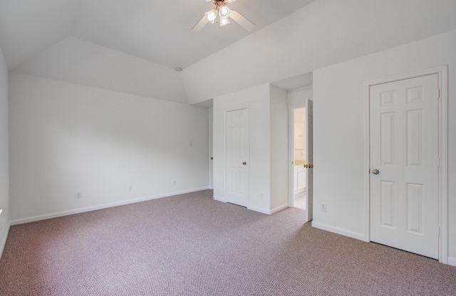 unfurnished bedroom featuring ceiling fan, carpet flooring, and vaulted ceiling