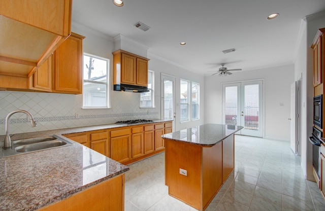 kitchen featuring french doors, stainless steel gas cooktop, sink, crown molding, and a kitchen island