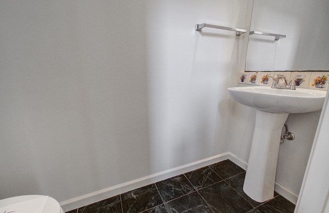 bathroom with tasteful backsplash and toilet