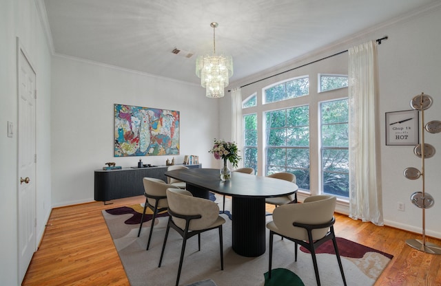 dining room featuring hardwood / wood-style flooring, crown molding, and an inviting chandelier