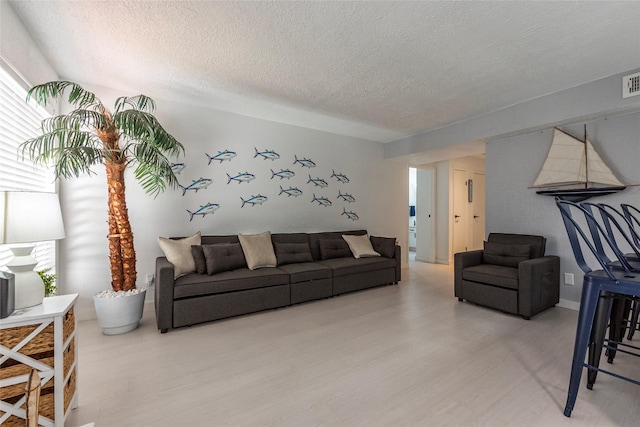 living room featuring a textured ceiling and light hardwood / wood-style flooring