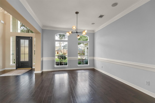 foyer entrance with dark wood-type flooring, crown molding, and a chandelier