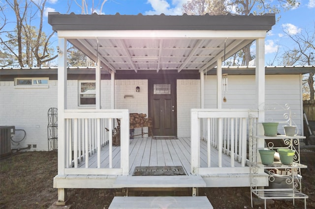 doorway to property featuring a wooden deck and central air condition unit