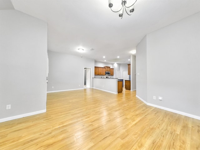 unfurnished living room featuring light hardwood / wood-style floors and a chandelier