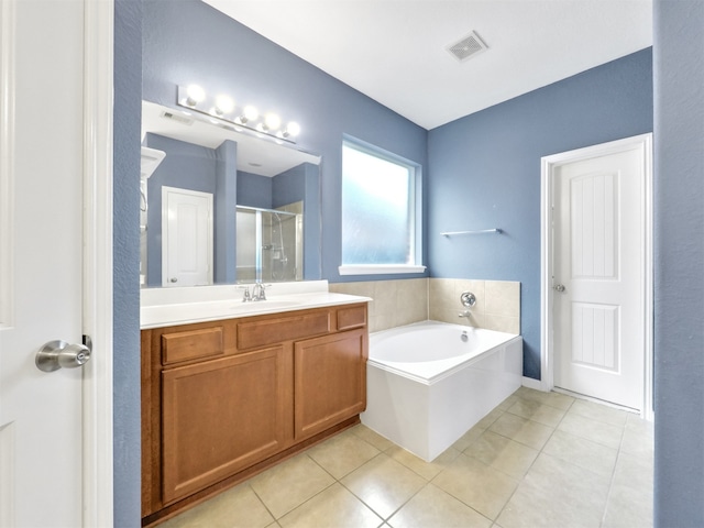 bathroom with tile patterned floors, shower with separate bathtub, and vanity