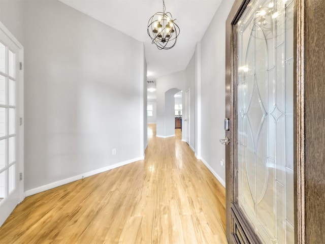 hall featuring light hardwood / wood-style flooring and a notable chandelier