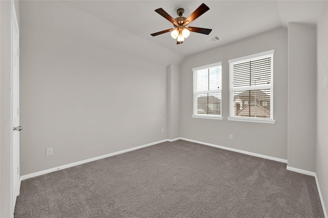 empty room with lofted ceiling, dark carpet, and ceiling fan