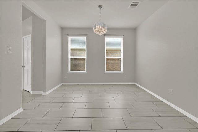 spare room with a notable chandelier