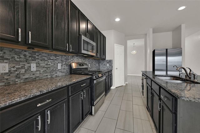 kitchen featuring tasteful backsplash, appliances with stainless steel finishes, sink, and dark stone countertops