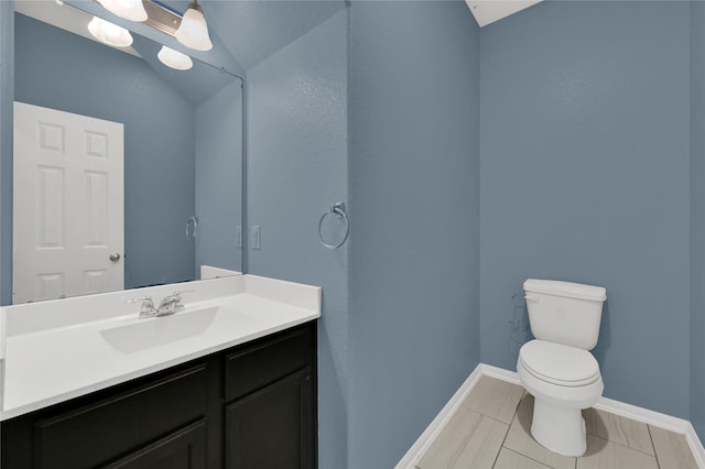 bathroom with vanity, toilet, and vaulted ceiling