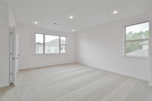 spare room with plenty of natural light and light colored carpet