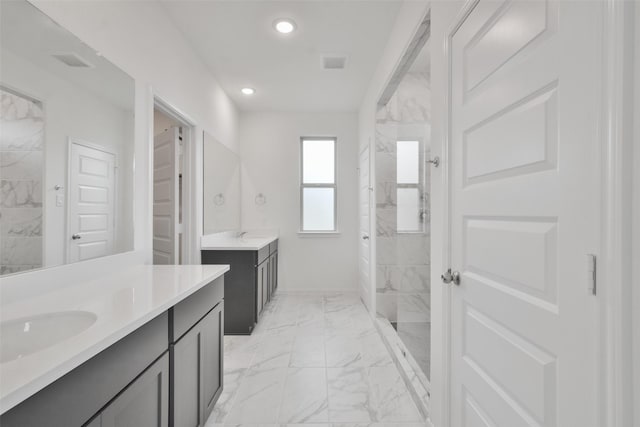 bathroom with a tile shower and vanity