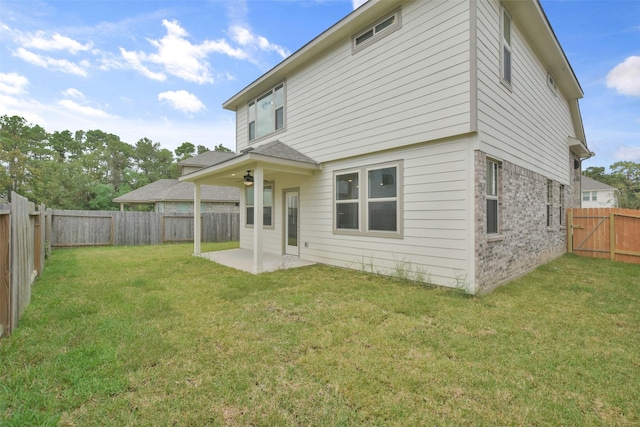 back of property with a yard and a patio area