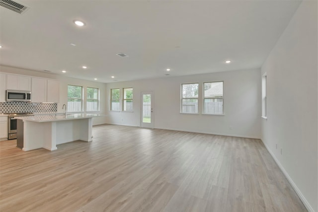 unfurnished living room with sink and light hardwood / wood-style flooring