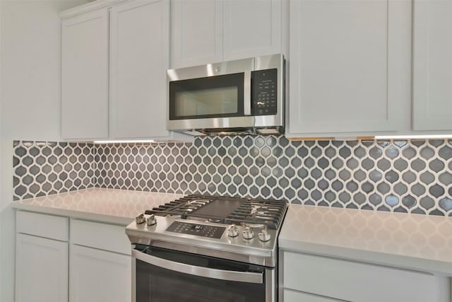 kitchen featuring white cabinetry, appliances with stainless steel finishes, and backsplash