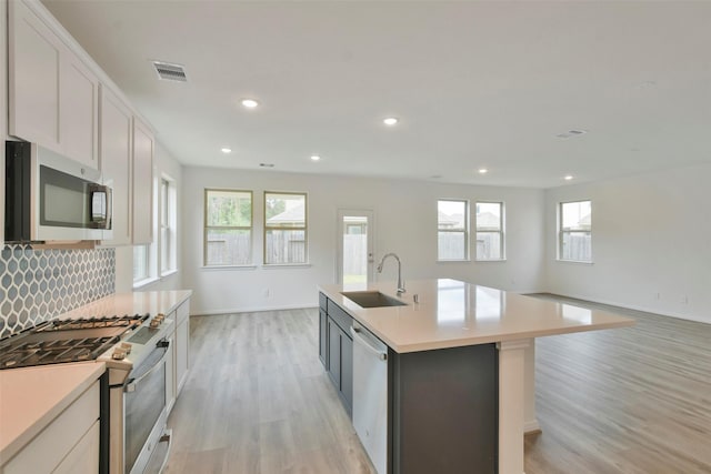 kitchen featuring white cabinetry, an island with sink, appliances with stainless steel finishes, and sink