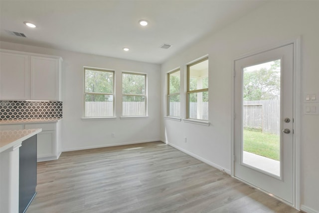 unfurnished dining area featuring light wood-type flooring