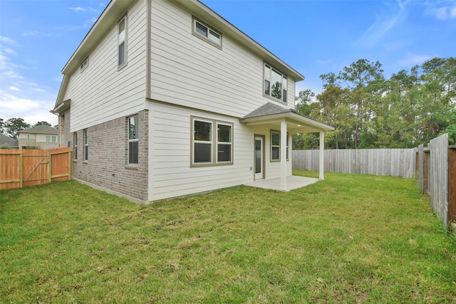 back of house with a patio and a lawn