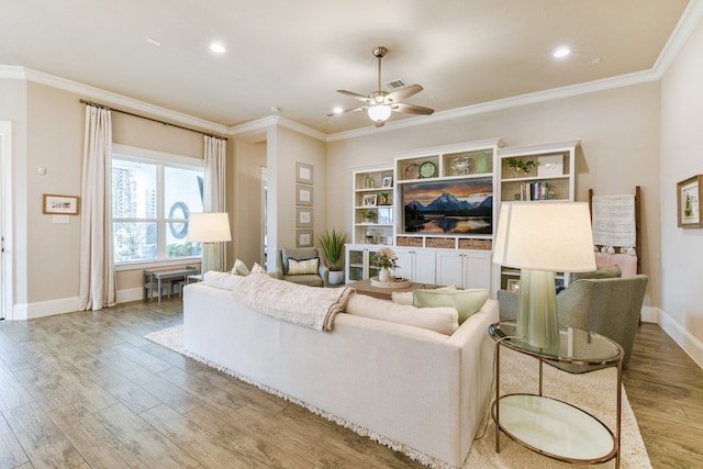 living room featuring ornamental molding, ceiling fan, and light hardwood / wood-style flooring