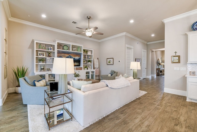 living room featuring ceiling fan, ornamental molding, and light hardwood / wood-style flooring