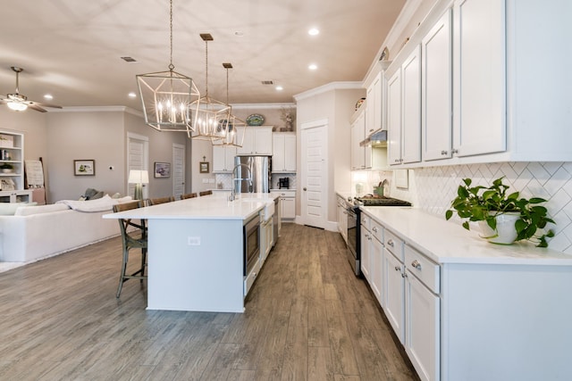 kitchen featuring white cabinetry, appliances with stainless steel finishes, a large island, and hanging light fixtures