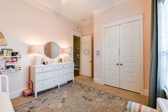 carpeted bedroom with crown molding and a closet