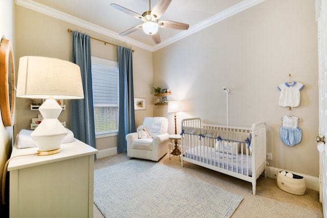 carpeted bedroom featuring crown molding, a crib, and ceiling fan