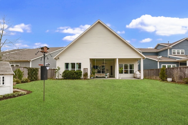 back of property with a patio, a yard, and ceiling fan