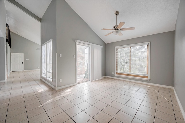 tiled spare room featuring a textured ceiling, high vaulted ceiling, and ceiling fan