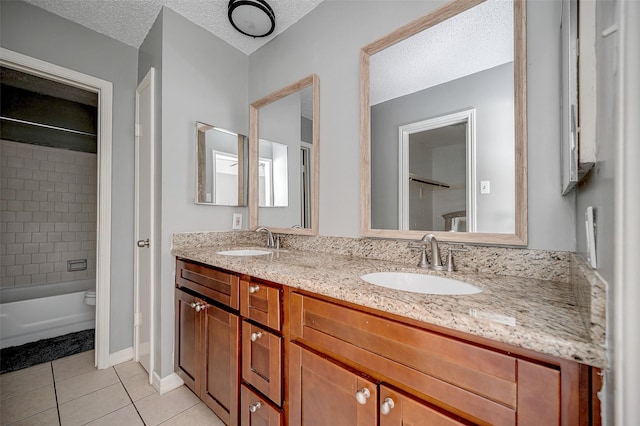 full bathroom featuring toilet, a textured ceiling, vanity, tiled shower / bath combo, and tile patterned flooring