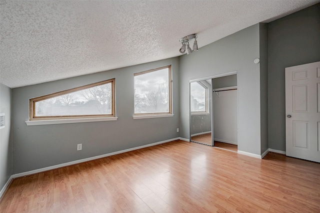 unfurnished bedroom featuring a closet, a textured ceiling, and light hardwood / wood-style flooring