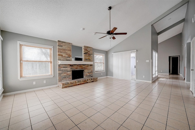 unfurnished living room with ceiling fan, a fireplace, a textured ceiling, and light tile patterned floors