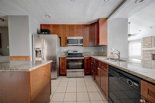 kitchen with sink, ceiling fan, stainless steel appliances, light stone counters, and light tile patterned flooring