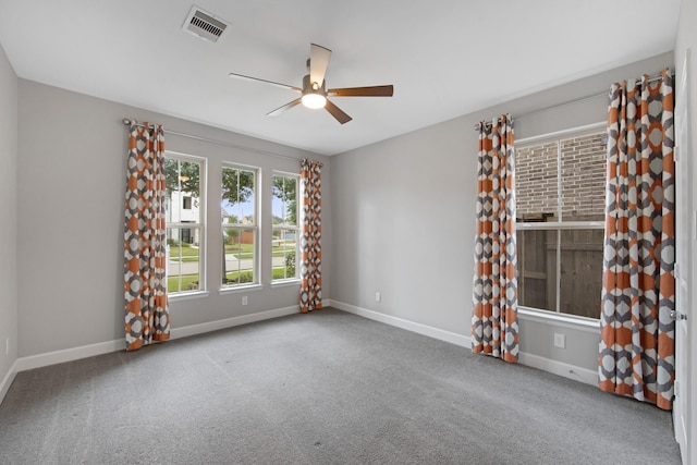 empty room with ceiling fan and light carpet