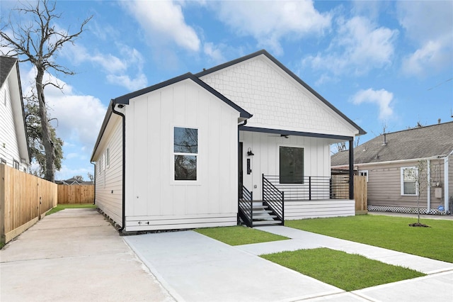 view of front of house featuring covered porch and a front lawn