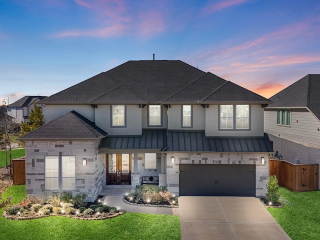 view of front of home featuring a garage and a lawn