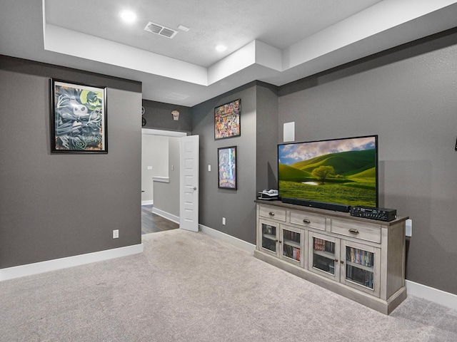 living room with light colored carpet and a tray ceiling