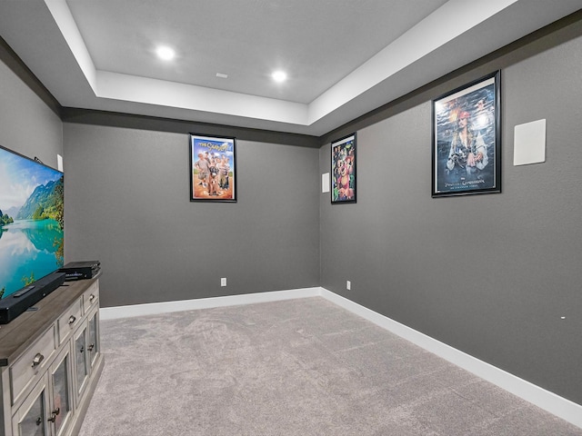 interior space featuring a tray ceiling and light carpet