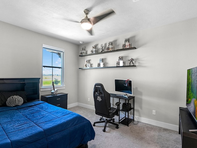 carpeted bedroom featuring ceiling fan and a textured ceiling