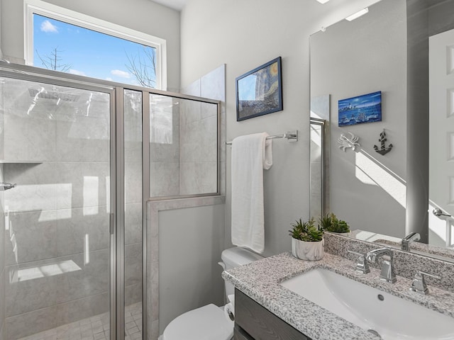 bathroom featuring toilet, vanity, and walk in shower