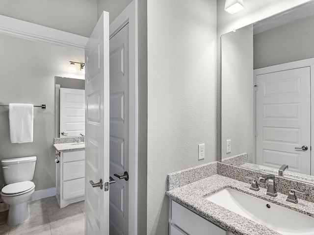 bathroom featuring vanity, tile patterned flooring, and toilet