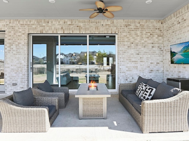 view of patio with ceiling fan and an outdoor living space with a fire pit