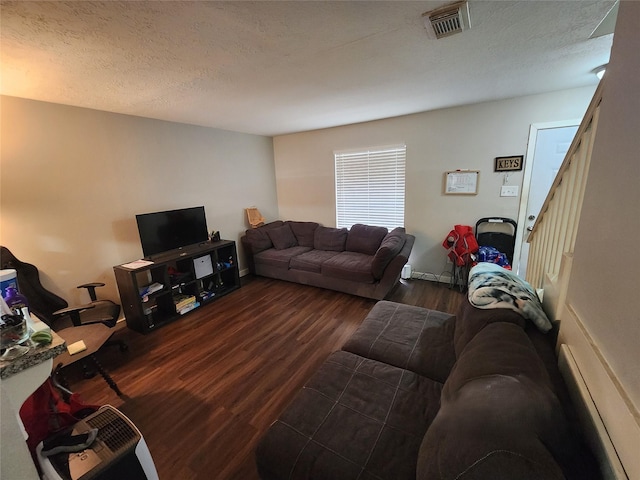 living room with dark hardwood / wood-style flooring and a textured ceiling